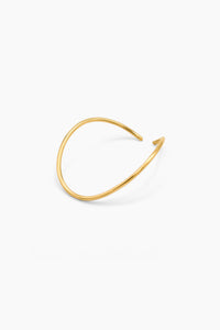 A minimalist, open-ended gold wire cuff bracelet with a smooth, polished finish, displayed on a clean white background.