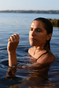 The model is wearing the three finger ring with a beautifiul minimalist curvev in the water and a choker of 3 mm. Handmade out of Brass.