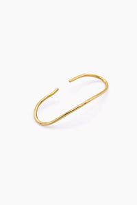 A minimalist gold wire cuff handcuff with an open, curved design, displayed on a clean white background. Handmade in Brass and silver