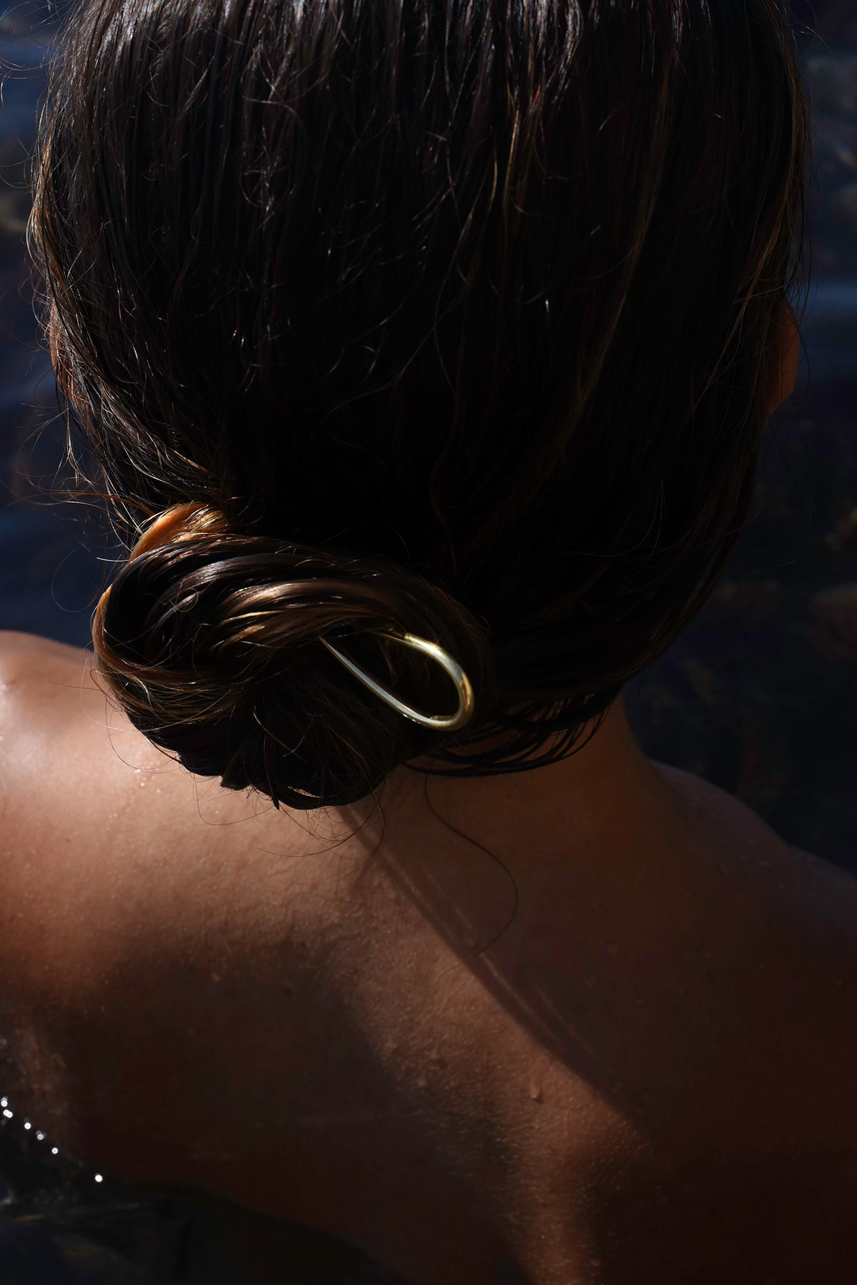 Gold Delos hair pin styled in a wet hair bun, MVDT Collection Ortigia.