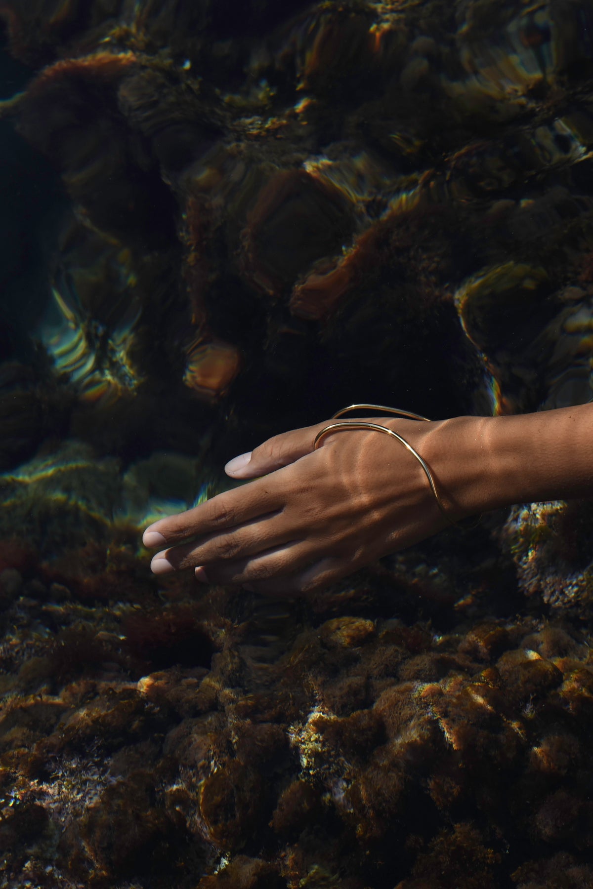 Delos handcrafted thump hand bracelet in gold worn underwater in the Mediterranean Sea, MVDT Collection.