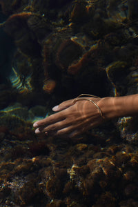Delos handcrafted thump hand bracelet in gold worn underwater in the Mediterranean Sea, MVDT Collection.